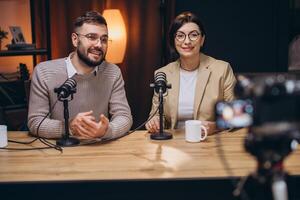Podcasters recording interview in professional studio, multiple microphones, camera capturing dynamic discussion between speakers photo