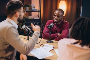 Podcasters collaborating during live recording, speaking into microphones within sleek professional studio environment photo