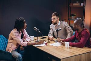 Three radio hosts interviewing a guest in a professional podcast studio, engaging in a discussion and creating audio content photo
