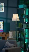 Vertical Cozy high end apartment illuminated with neon lights and a big tv, home theatre and setup for a young adult. Empty loft decorated and equipped with electronics, comfortable space. video