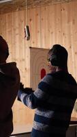 Vertical Group of friends in firing range doing recreational shooting activity with firearm, hitting bullseyes. People in shooting gallery training with handguns, sharpening skills, camera A video