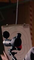 Vertical Firing range client doing shooting activity next to friends, zooming to check if he shot bullseye. Person analyzing targets shot using magnifying lens, comparing results with mates, camera B video
