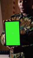 Vertical Team of military units at shooting range watching on green screen tablet to learn necessary combat skills. Army soldiers looking at instructions on chroma key device during training, camera B video