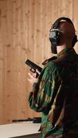 Vertical Happy military personnel in firing range shoots targets with handgun, satisfied after achieving positive result. Joyous soldier training with firearm exults after accurately hitting bullseye, camera A video