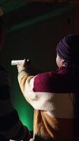 Vertical Shooting gallery staff member teaching student how to hold and handle handgun. Firing range expert providing guide to african american woman learning how to achieve proficiency with guns, camera A video