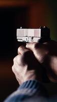 vertical disparo rango cliente dispara con pistola, atractivo objetivos a extendido rango. africano americano hombre a disparo suelo disparo letal fuego arma, vistiendo proteccion equipo, cámara si cerca arriba video