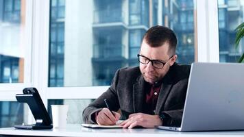 Businessman using laptop in office. Happy middle aged man, entrepreneur, small business owner working online. Using computer remote studying, virtual training, watching online webinar video
