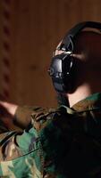 Vertical Man in firing range shooting targets with pistol doing face palm after missing. Disappointed person training with weapon feeling upset after failing to hit bullseyes, camera B video