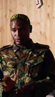 Vertical Army commander talking with recruits in shooting gallery, teaching them about weapons handling at close quarters. Military officer instructing soldiers, building combat habits, camera B video