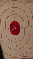 Vertical Army leader teaches recruits in shooting gallery how to shoot target center, training accuracy. Military officer instructs soldiers how to hit bullseye, explaining shooting practices, camera A closeup video