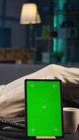 Vertical African american young adult laying on the sofa next to mockup copy space, relaxing and browsing web on his smartphone. Happy relaxed person on the couch feels happy with remote job. Camera B. video