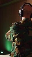 Vertical Army soldier in shooting range reloads pistol, shooting target, testing accuracy, looking at results. Military man in firing range practices with weapon, checking to see if he shot bullseye, camera A video