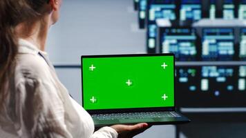 Licensed tech support in server farm housing high end supercomputers capable of quickly and efficiently performing complex computations and data analysis, using mockup laptop to remove dangers photo