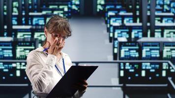 Knowledgeable serviceman in data center equipped to handle complex computational operations, doing regular upgrades to server units, increasing processing power to prevent hazards photo