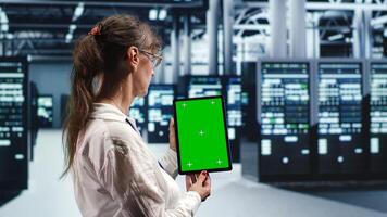 Senescent expert in servers facility housing high end processors capable of quickly and efficiently performing complex computations and data analysis, using mockup tablet to service hardware photo
