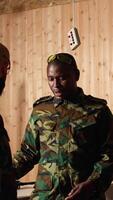 Vertical Army commander talking with recruits in shooting gallery, teaching them about weapons handling at close quarters. Military officer instructing soldiers, building combat habits, camera A video