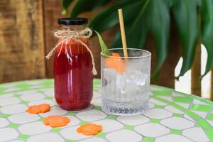 Healthy mixed juice made of carrot, orange fruit pink dragon fruit, apple with glass with ice photo