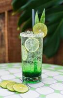 Panda leaves lemonade with desiccated coconut and green syrup on natural leaves background with copy space photo