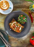Smashed avocado with poached eggs red pepper pesto and pickle shallot on toast top view photo