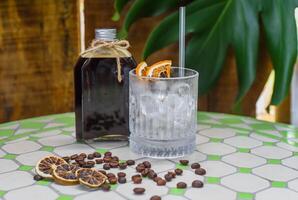 Cold brew coffee in a bottle with transparent glass full of ice photo