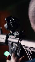 Vertical Shooting gallery client hitting paper targets with ammo, extreme close up of rifle. Close up of person at firing range establishment shooting bullseyes, enjoying using semiautomatic weapon, camera B video