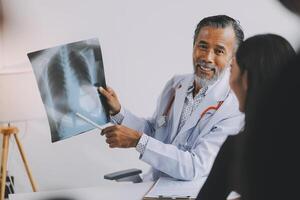 A doctor is showing a x - ray to a patient photo