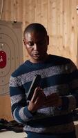 Vertical Shooting range safety officer demonstrating how to safely reload firearms to customers, ensuring they follow rules. Firing range employee teaching proper weapon handling and usage, camera A video