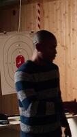 Vertical Shooting gallery worker meeting with customers, greeting them, demonstrating how to safely reload pistol. Firing range expert welcoming clients, doing hand shake, teaching weapon handling, camera A video