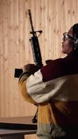 Vertical Shooting gallery client using rifle to hit targets, getting congratulated by instructor after great result. Woman doing thumbs up after receiving compliments for shooting bullseye, camera A video