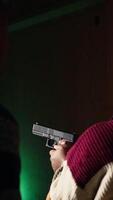 vertical disparo galería trabajador enseñando estudiante cómo a sostener pistola, cerca arriba. disparo rango especialista Proporcionar guía a mujer aprendizaje cómo a lograr alto nivel de competencia con armas de fuego, cámara un video