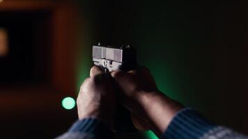 Shooting gallery client using handgun to hit paper targets with ammo. Close up shot of person wearing safety gear at indoor firing range facility shooting bullseyes, enjoying using weapons, camera B video