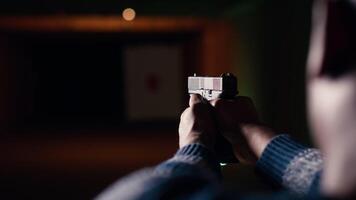 Man in shooting gallery using firearm, looking at results on moving target. Close up of person training for competitive shooting sport, sharpening skills, checking points scored on bullseye, camera B video