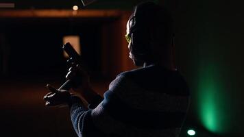 Man reloading handgun in indoor shooting range next to friends firing at targets. Person loading weapon following firearms safety rules next to people shooting bullseyes, camera B video