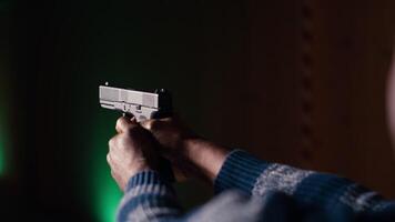 Shooting gallery customer using pistol to hit paper targets with ammo. Close up shot of man at professional firing range facility shooting bullseyes, enjoying using weapons, camera B video