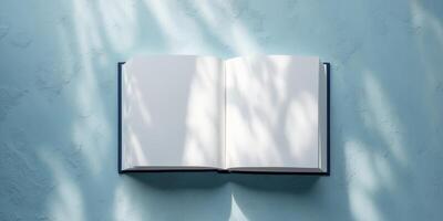 Open blank book on textured blue background with copy space for text insertion. photo