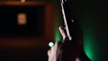 Man holding pistol enjoying recreational indoor shooting experience in firing range facility, close up. Person practicing with handgun in safe environment at shooting range company, camera B video