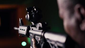 Man holds assault rifle, enjoying recreational shooting experience in firing range. Person practices with semiautomatic weapon in safe environment at shooting range company, camera B extreme close up video