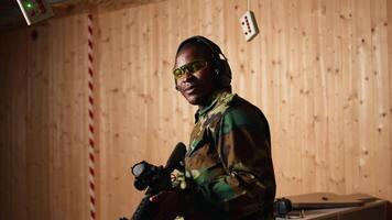 Portrait of happy soldier holding assault rifle, developing marksmanship skills in firing range. Joyous military unit wearing uniform practices with semiautomatic weapon, camera A video