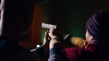 disparo galería trabajador enseñando estudiante cómo a sostener pistola, cerca arriba. disparo rango especialista Proporcionar guía a mujer aprendizaje cómo a lograr alto nivel de competencia con armas de fuego, cámara si video
