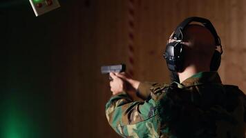 Man in firing range shooting targets with pistol doing face palm after missing. Disappointed person training with weapon feeling upset after failing to hit bullseyes, camera B video
