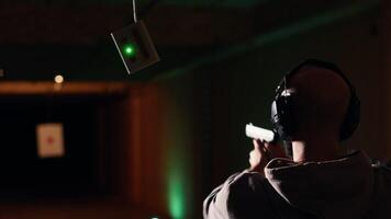 Group of friends in firing range doing recreational shooting activity with firearm, hitting bullseyes. People in shooting gallery training with handguns, sharpening skills, camera B video