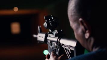 Shooting gallery client hitting paper targets with ammo, extreme close up of rifle. Close up of person at firing range establishment shooting bullseyes, enjoying using semiautomatic weapon, camera B video