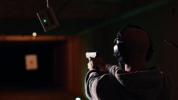 Company coworkers enjoying recreational shooting experience in firing range during teambuilding. Workplace colleagues practicing with weapons in safe shooting range environment, camera B video