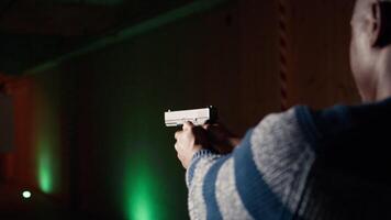 Man in shooting gallery using firearm, looking at results on moving target. Close up of person training for competitive shooting sport, sharpening skills, checking points scored on bullseye, camera A video