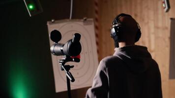 Friends in firing range doing recreational shooting, using magnifying lens to see targets. People training with handguns, sharpening skills, zooming to check points scored on bullseyes, camera B video