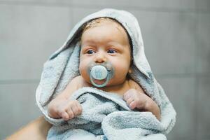 A baby with a pacifier in his mouth. A child sucks a pacifier. photo