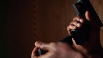 Man holding pistol enjoying recreational indoor shooting experience in firing range facility, close up. Person practicing with handgun in safe environment at shooting range company, camera A video