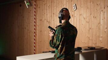 Happy military personnel in firing range shoots targets with handgun, satisfied after achieving positive result. Joyous soldier training with firearm exults after accurately hitting bullseye, camera A video