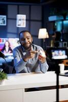African american online content creator discussing subject related to home enhancement. Internet show host presenting intelligent light bulb to viewers, demonstrating features photo