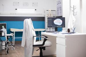 Modern clinic workstation features desktop pc displaying brain scan with organized desk in clean empty office. Computer monitor in hospital room is showing diagnostic results for neurological tests. photo